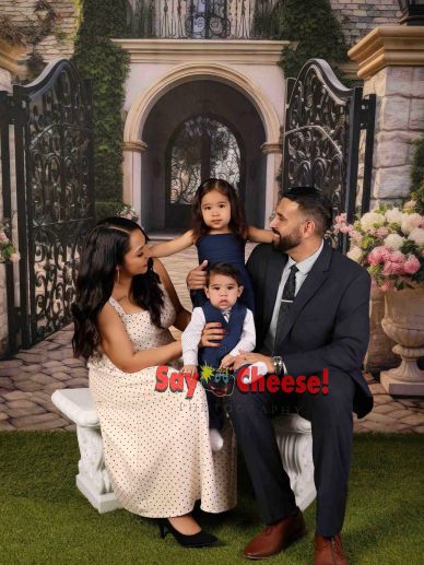 Family portrait with parents and two children in formal attire.