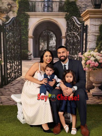 Family photo with parents and two children, smiling.