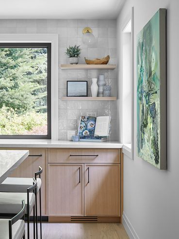 Kitchen with natural lighting and warm-colored wooden cabinets, complemented by stylish furniture.
