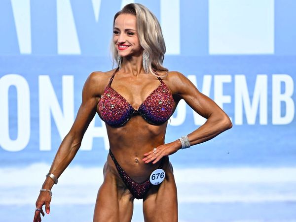 Fitnesskilpailija esittelee fysiikkaansa kilpailulavalla.