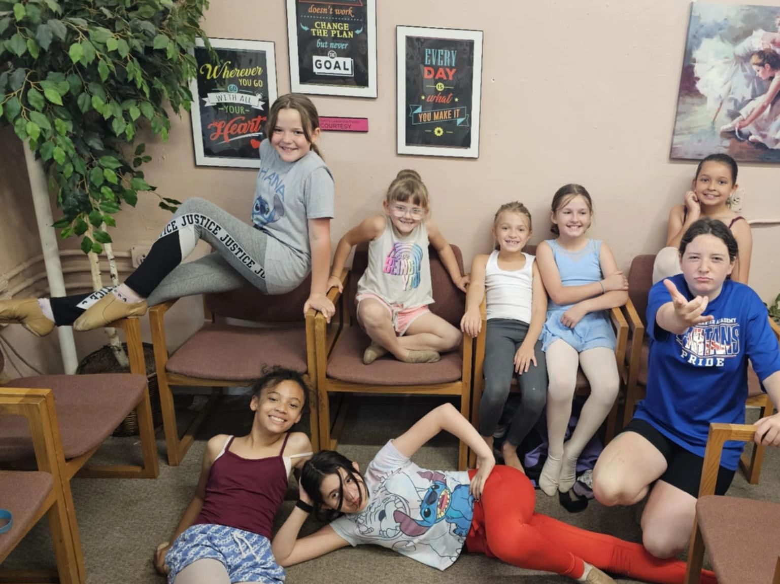 Group of smiling girls posing playfully indoors.