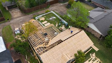 Aerial view of a house with new decking being added before new roof.