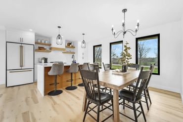 Bright, modern kitchen and dining area with wooden floors and black accents.