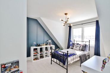 Bright bedroom with Star Wars LEGO display and sports-themed bedding.