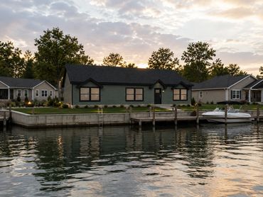 Energy-efficient modular home built on a scenic lakefront channel with nearby cottages