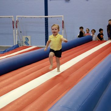 A young child running on a inflated structure