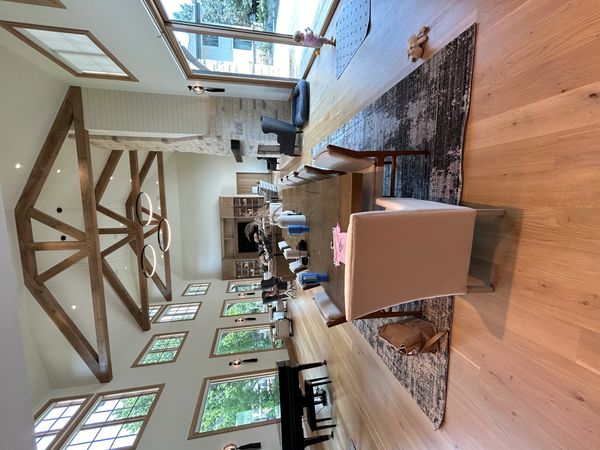 Spacious modern dining room with high wooden beams and large windows.