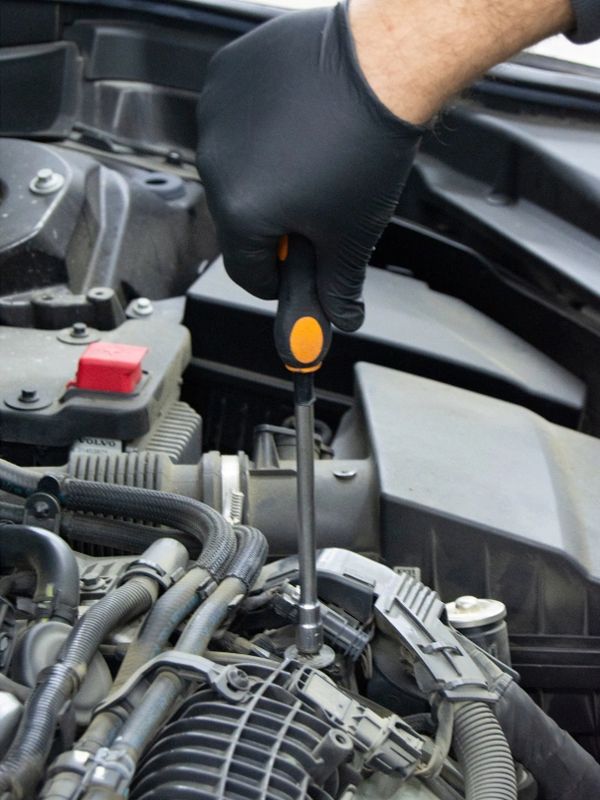 Hand with screwdriver auto mechanic in car repair