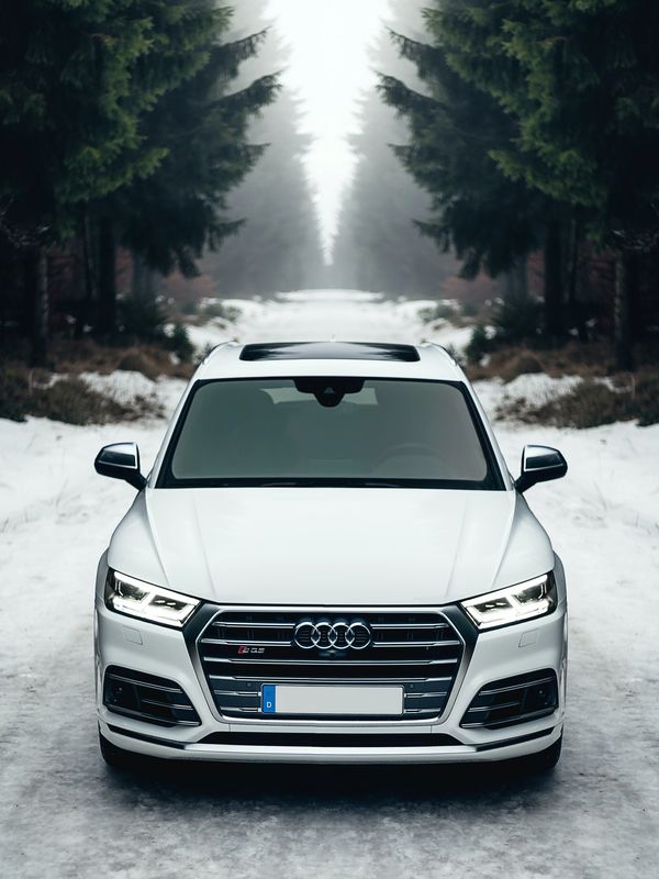 White Audi SUV on a snowy road.