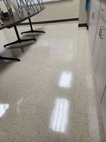 Clean tiled floor in a room with tables and cabinets.