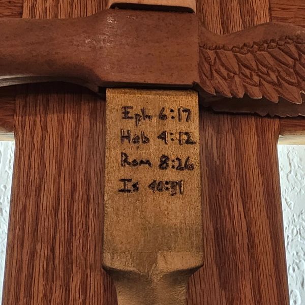 Cross with Biblical inscriptions on sword base. Daniel's Mission & partners