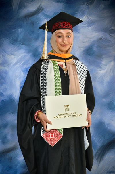 Graduate in cap and gown holding diploma.