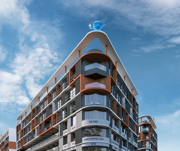 Modern commercial building complex with shops, gym, and cafe under a clear sky.