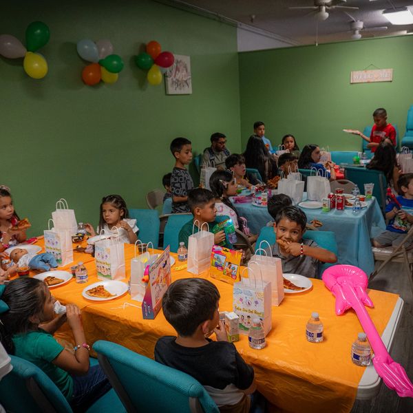Children enjoying a birthday party with food and decorations indoors.