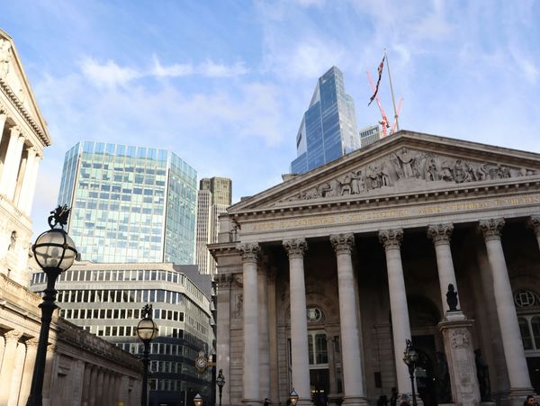 Historic building with columns in front of modern skyscrapers on a clear day.