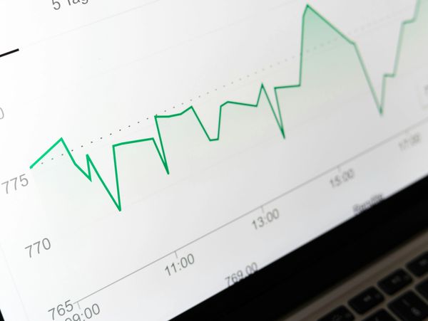Close-up of a fluctuating green line graph on a computer screen.