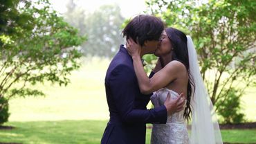 Bride and groom share a romantic kiss outdoors on their wedding day.