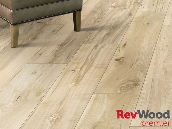 Light wood laminate flooring with natural grain patterns under a piece of furniture.