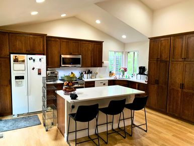 Bright modern kitchen with wooden cabinets and a central island with stools.
