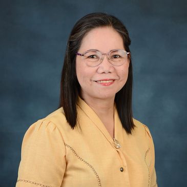 Smiling woman wearing glasses and a yellow blouse.
