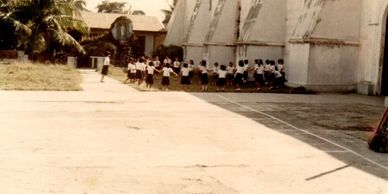 Children playing outside near a building on a sunny day.