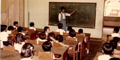 Teacher explaining math to students in classroom.