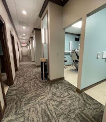 Hallway of a dentist office where a dentist chair can be seen.