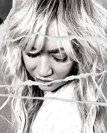 Black-and-white portrait of a woman with closed eyes and torn paper overlay.