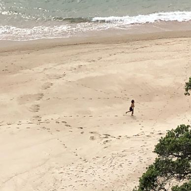 Aerial view of the running woman on the white sandy beach