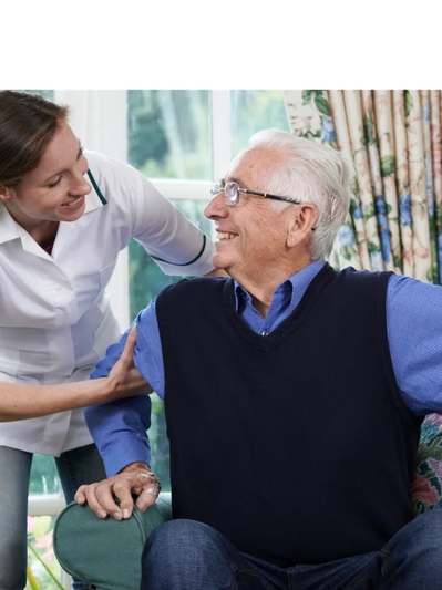 A nurse warmly assisting an elderly man sitting on a chair.