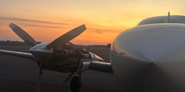 Light aircraft at sunset with engine exposed.