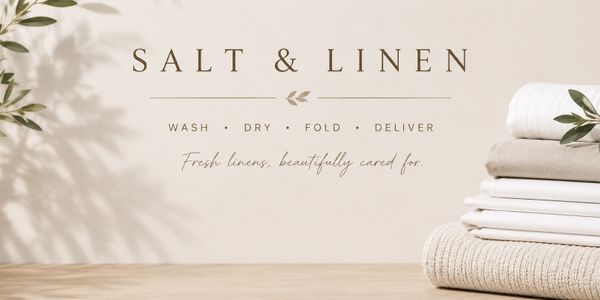 Salt & Linen laundry service with neatly folded fresh linens on a wooden surface.