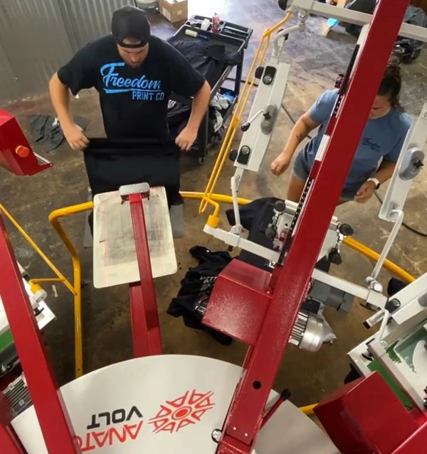 two persons doing screen printing