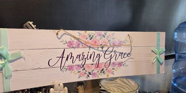 Wooden sign with floral design and 'Amazing Grace' text.