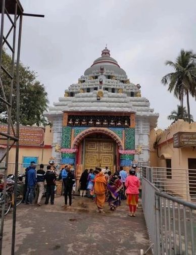 People visiting a decorated temple entrance with ornate architecture.