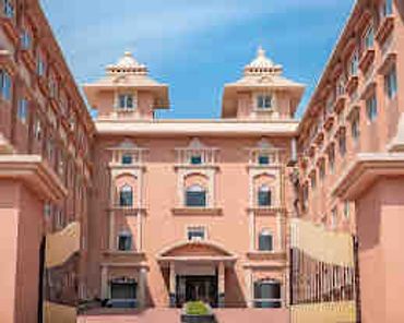 Symmetrical pink building with classical architectural elements.