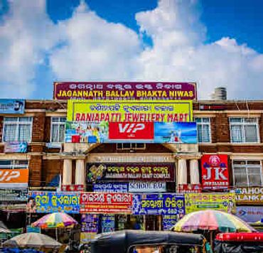 Facade of a commercial building with multiple business signs under a bright sky.