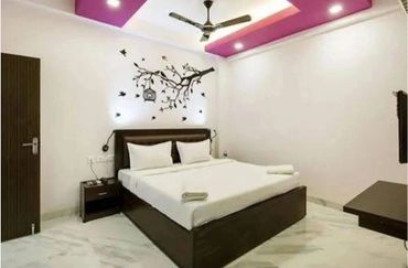 Modern bedroom with white walls, purple ceiling accents, and a bird-themed wall decal.