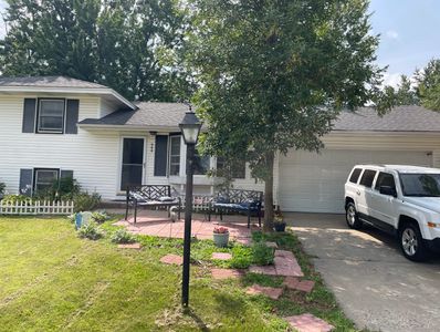 Cozy suburban house with a white exterior and a spacious driveway.