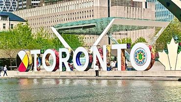 Colorful Toronto sign at Nathan Phillips Square with reflections in the water.