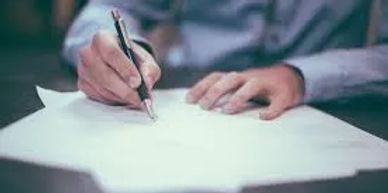Person signing a document with a pen.