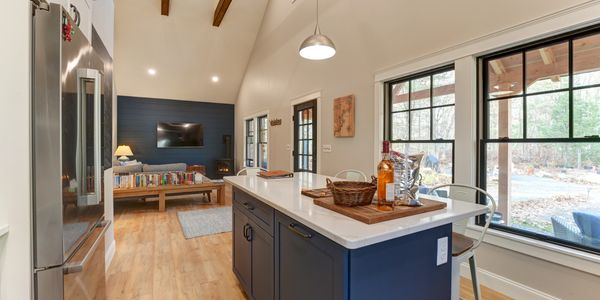 Modern kitchen island with blue cabinets and wood accents in a cozy living space.