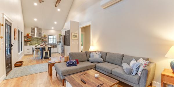 Cozy living room with gray sectional sofa and wooden coffee table under vaulted ceiling.