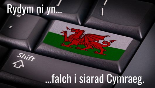 A keyboard with Welsh Dragon flag on a key stating that peple can speak Welsh