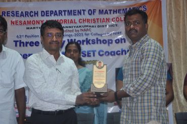Two men exchanging a trophy at a mathematics workshop event.