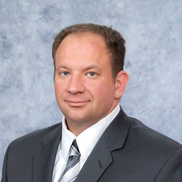 Professional portrait of a man in a suit and tie.