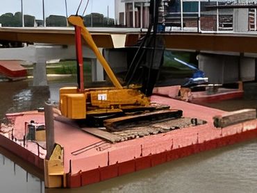 A yellow crane on a red floating platform works on a bridge pier over muddy water.