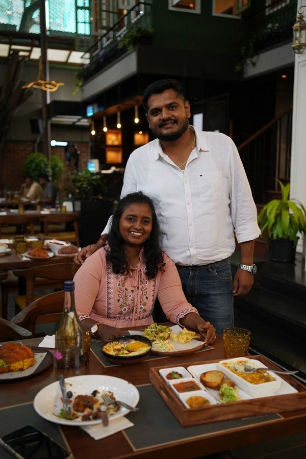 A smiling couple enjoying a meal at a cozy restaurant.