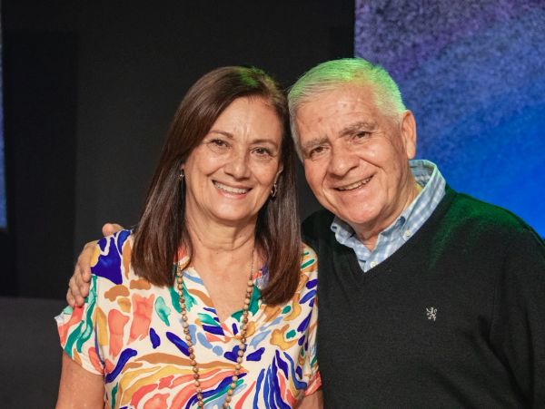 Pareja sonriente abrazada en un ambiente interior.