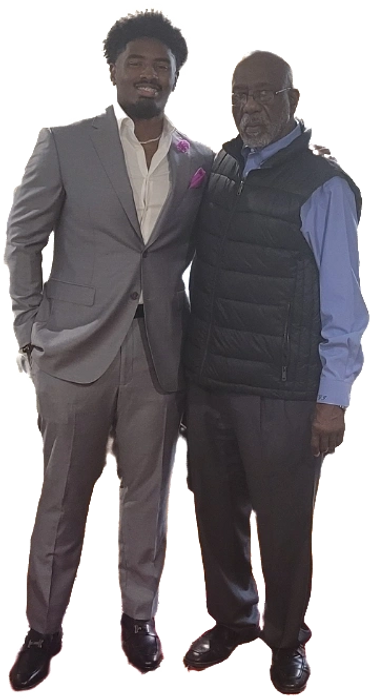 Two men posing together, one in a suit and the other in casual attire.